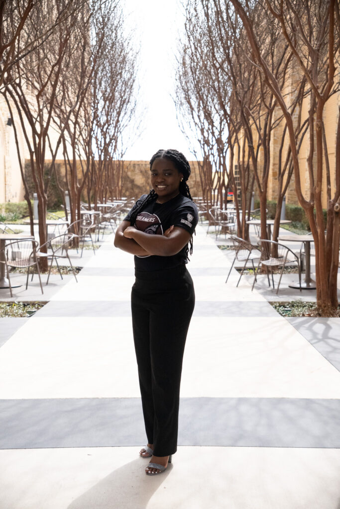 Janet Zulu standing with her arms crossed smiling.