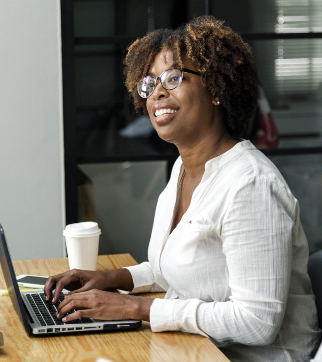 Woman using laptop next to her colleague